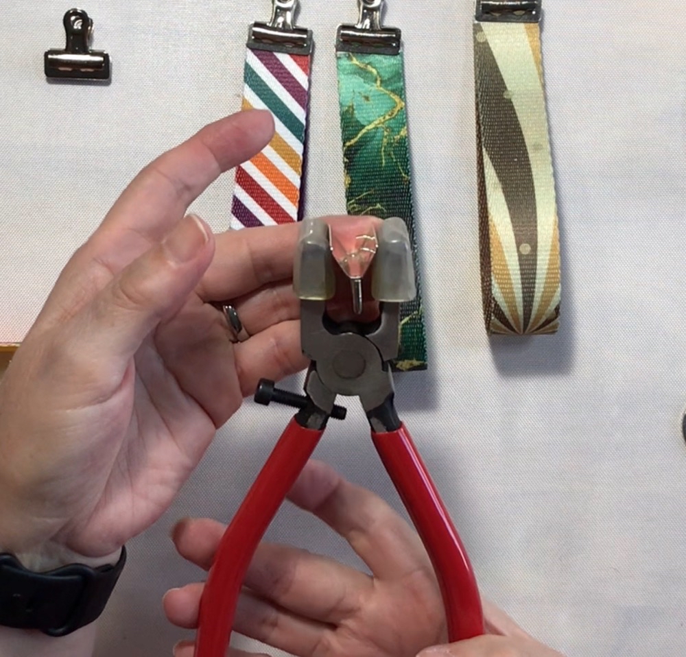 Photo showing the key fob hardware in the pliers ready to add the keychain webbing.