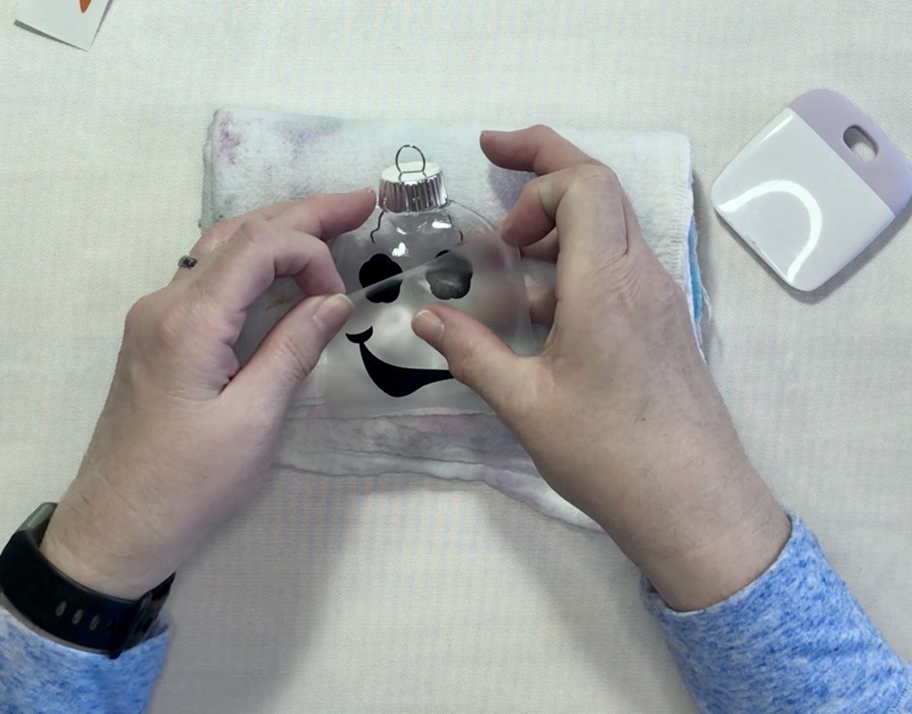 Photo showing applying just the eyes on the snowman ornament for today's Cricut Snowman Ornaments: Easy Holiday Tutorial post.