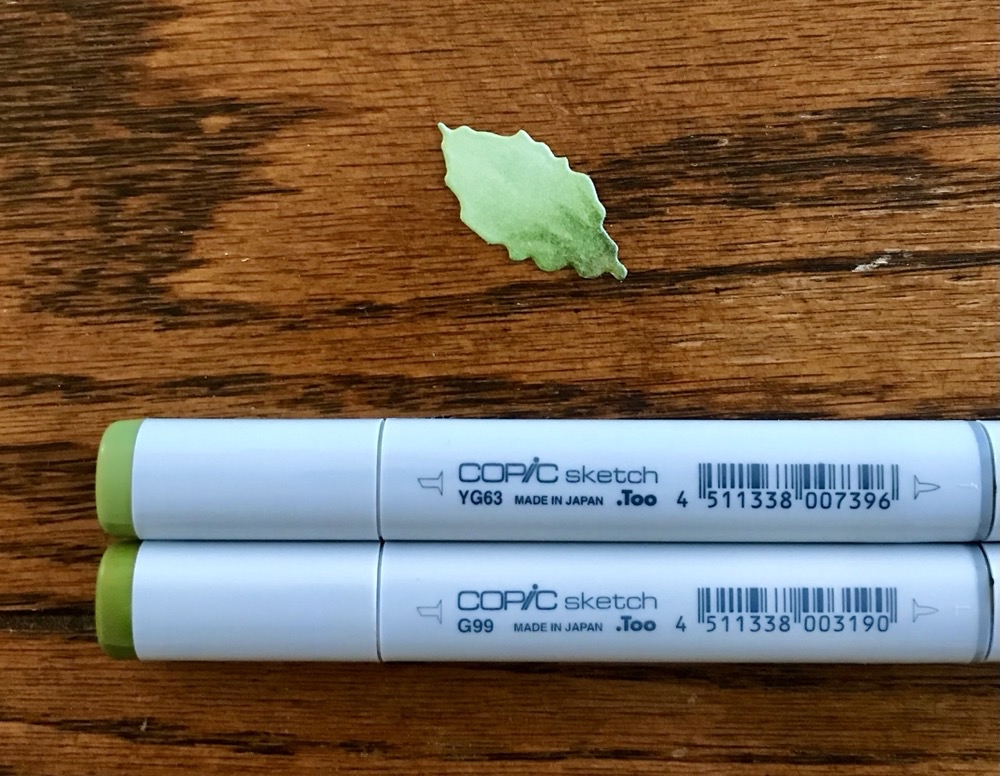 Photo of one of the leaves in the Christmas Rose die set colored with Copic Markers in YG63 & G99 for today's Christmas Rose Card for a Holiday Birthday post.