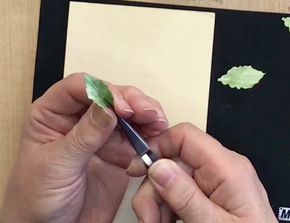 Photo showing how to pinch the leaf with your fingers to add even more dimension to the leaves for today's project.