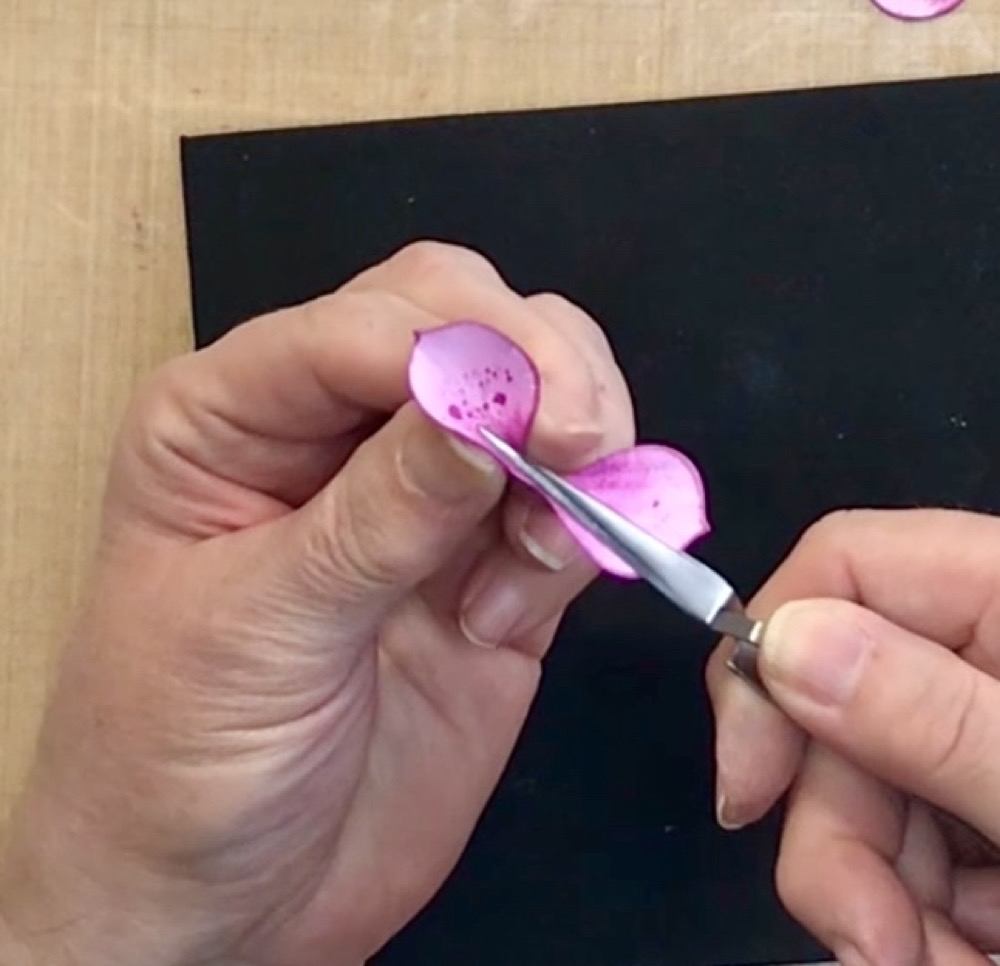 Photo showing how to grasp the petal with your tweezers before pinching the petal with your fingers to further shape it for today's Christmas Rose Card for a Holiday Birthday post.