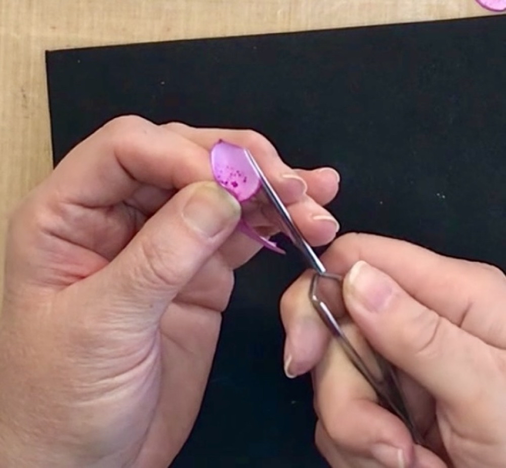 Finally, showing how to roll the edges of the petals with a pair of tweezers to give it a more life like appearance. 