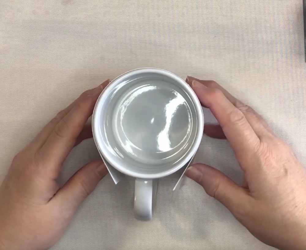 Photo showing how I line up the cut sublimation image on my 15oz Cricut Mug before taping it into place with heat resistant tape from Amzon. 