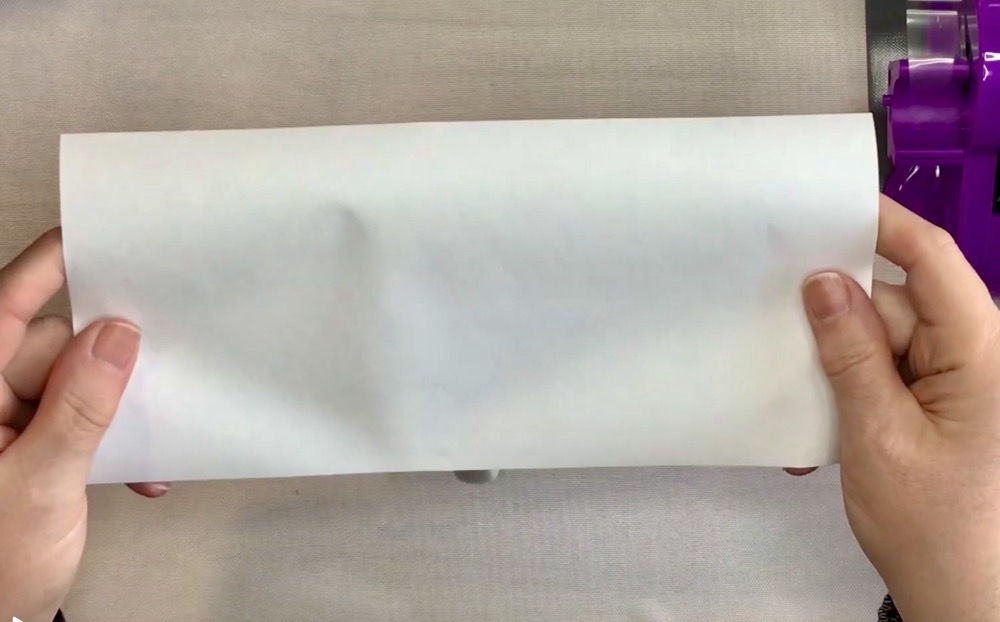 Photo showing a piece of uncoated white butcher paper used to wrap the mug to protect my Vevor Mug Press from sublimation ink for today's Perfect 15oz Cricut Mugs with My Canva Template post.
