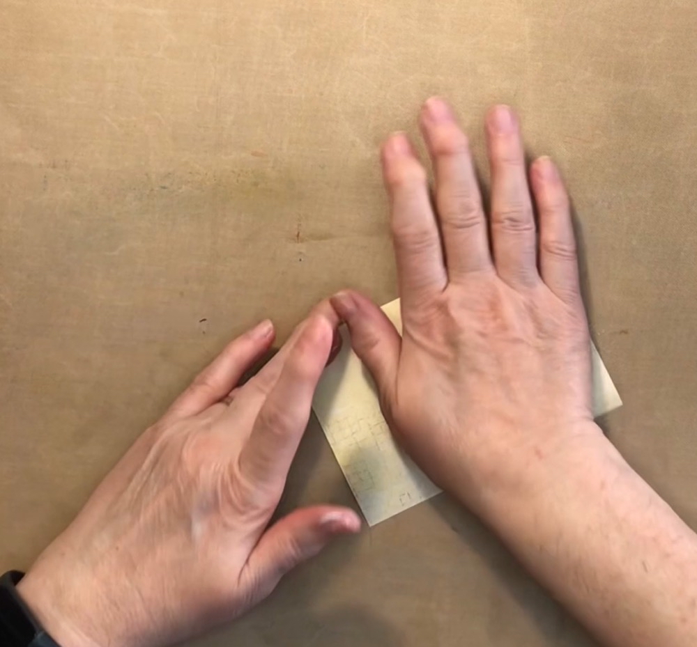 Photo showing how I applied the lotion to the paper by first rubbing to between my hands and them applying it to the front and back of each sheet.