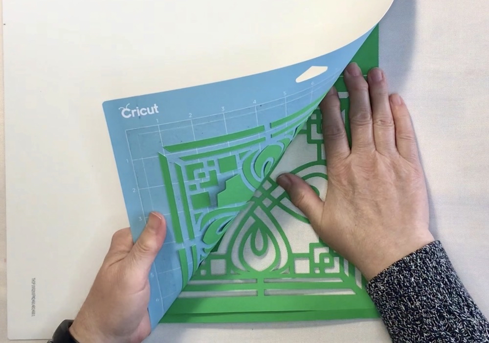 Photo showing the best way to remove any substrate from your Cricut Mat by pealing the mat away from your project.