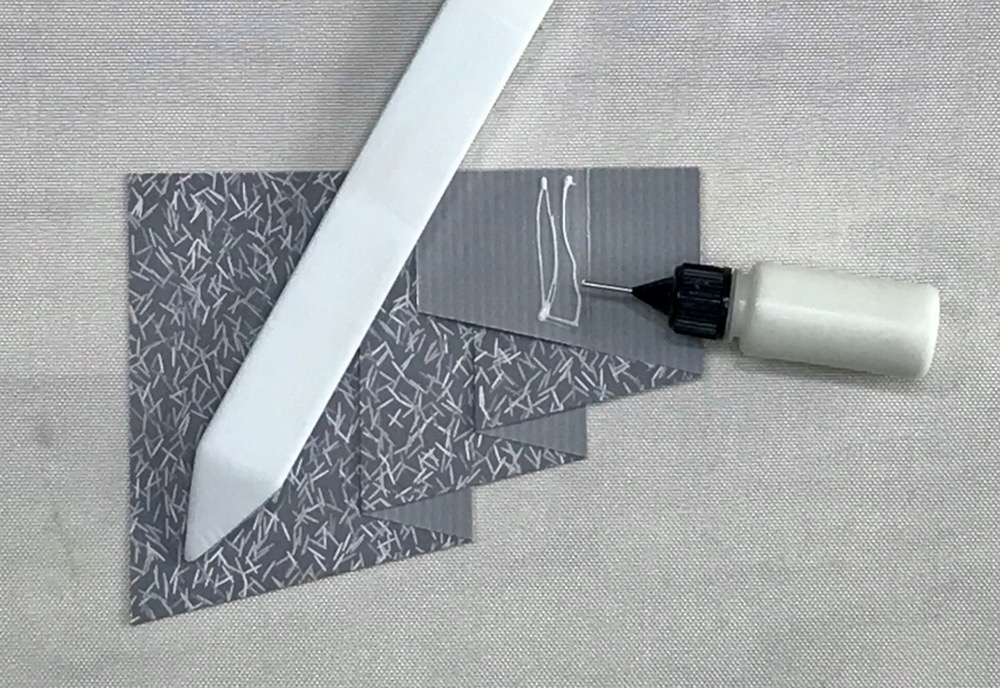 Photo showing how I also add glue to the back of the curtain to make applying it to the card base much easier.