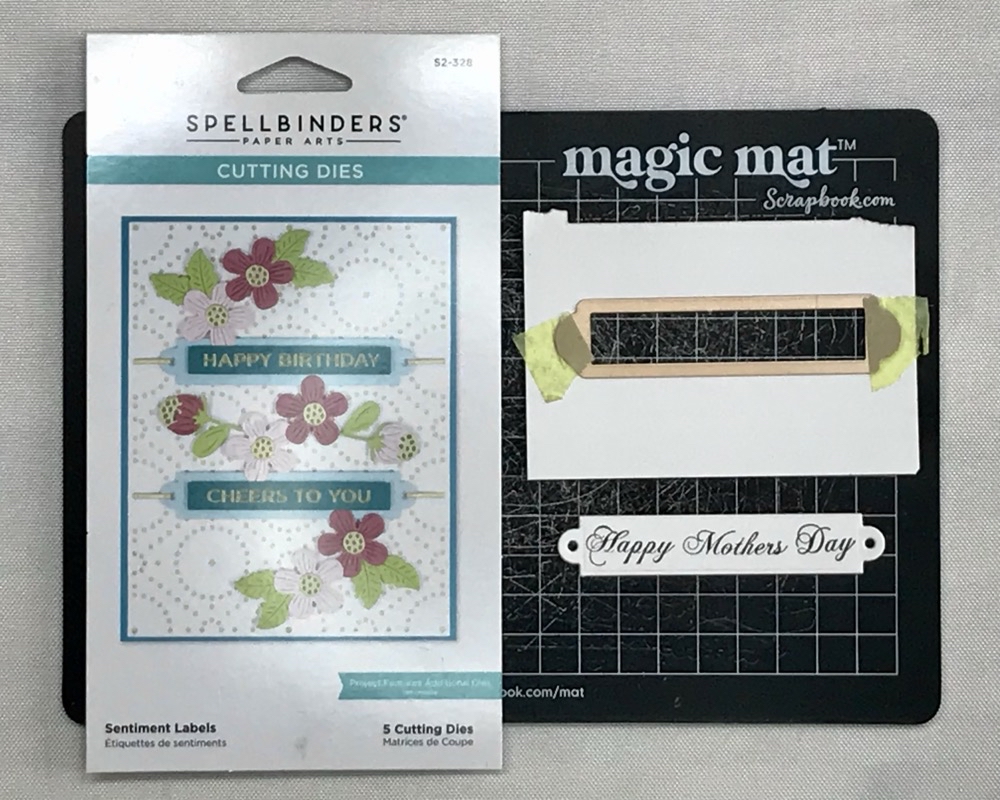 Photo of the trimmed sentiment with the scrapbook.com magic mat and Spellbinders Sentiment Labels die set.