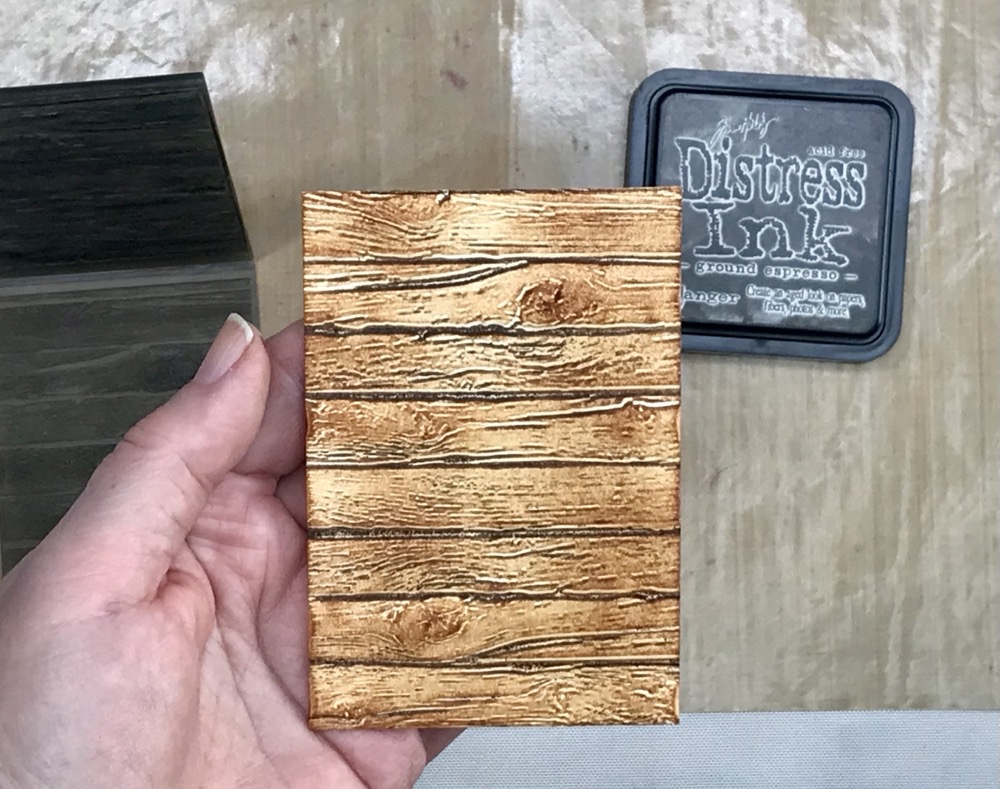 Photo showing the effect of adding the darker distress ink to the embossed card. 
