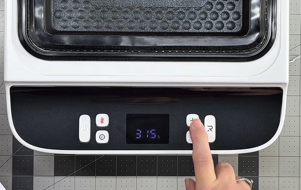 Photo showing the red light on the temperature button to set the temperature of the bottom heat plate.