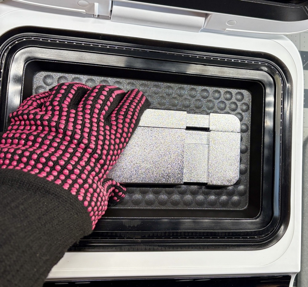 The best way to place the phone case on the fixture #1 - with a gloved hand squeeze the fixture closed.