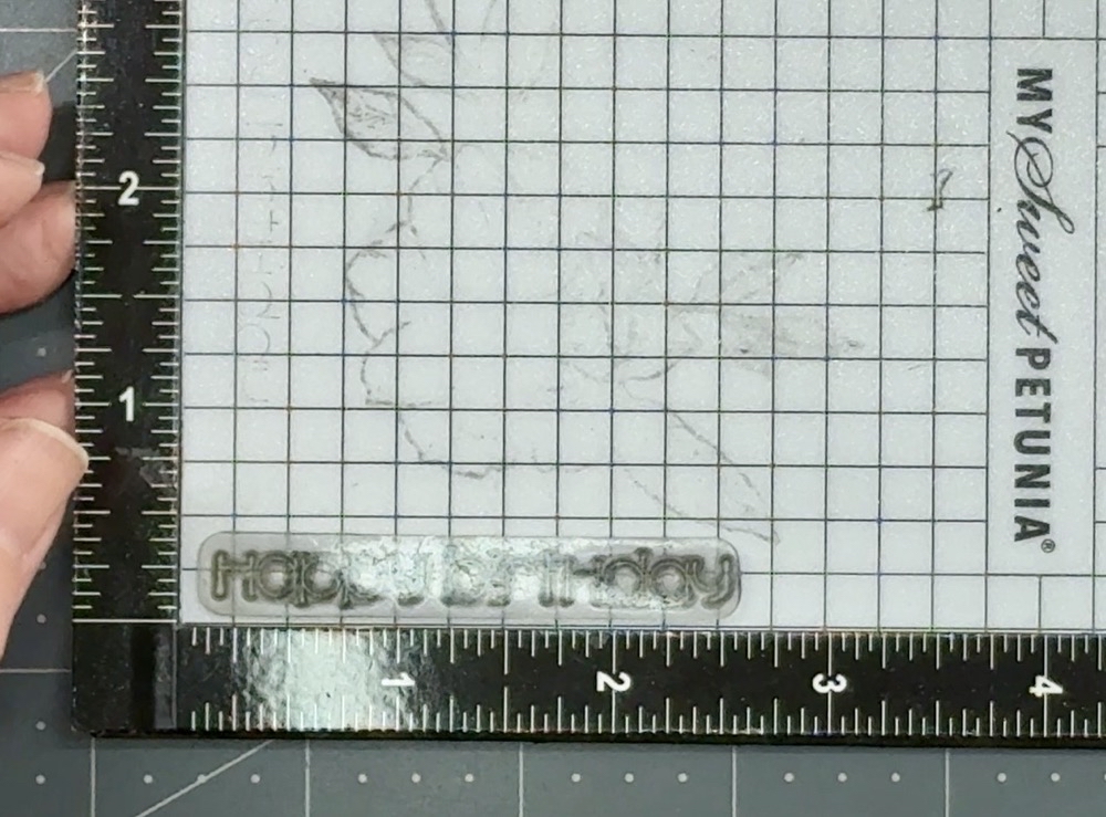 Screen shot showing how I am lining up the Happy Birthday stamp in the base of my Mini Misti stamping tool.