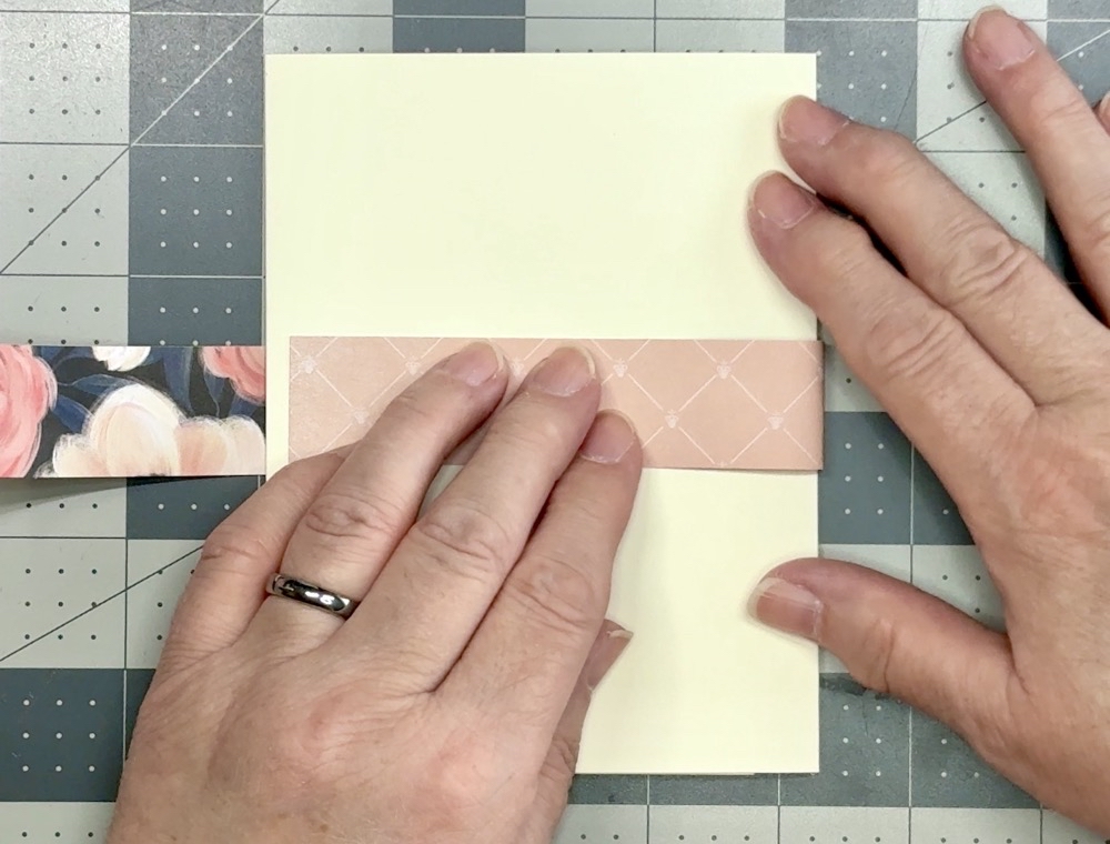 Screen shot showing how I have the finished card upside down on my work surface as I wrap the right side of the belly band around the card without creasing it.