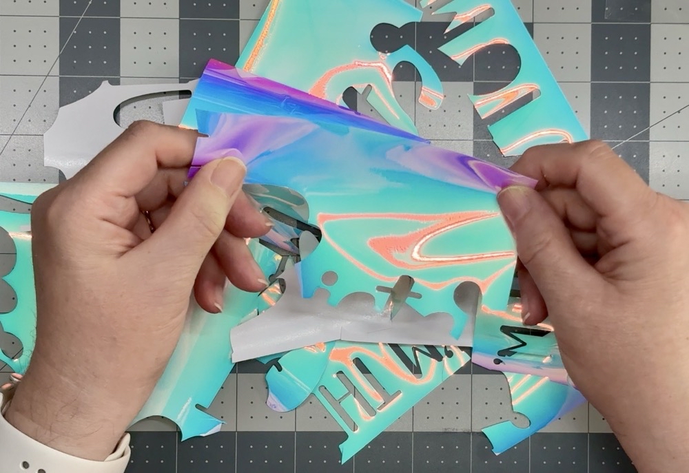 Photo showing the larger pieces of holographic vinyl removed from todayโs project so save for future projects.