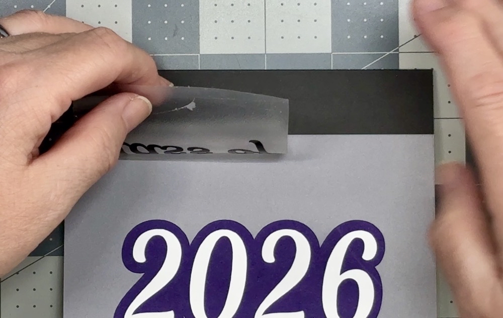 Screen shot showing the removal of the parchment paper before applying the vinyl down to the card for today’s 2026 Graduation Gift Card Holder project.