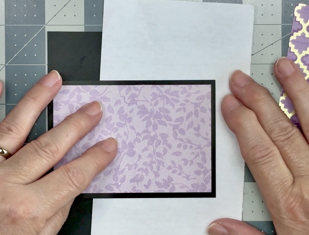 Screen showing how much easier it is to apply the pattern paper to the black cardstock front panel with a scrap piece of typing paper.