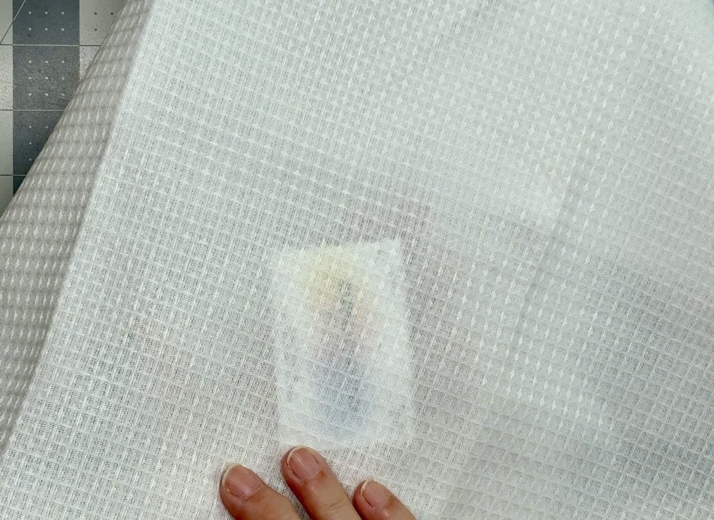 Photo showing how thin and see through the Sublimations Blanks waffle weave sublimation kitchen towel is.