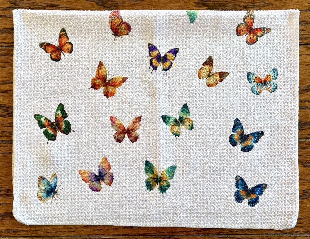 Photo of the front side of the Bonus All-over Butterfly kitchen towel with images from the Watercolor Autum Butterfly Clipart set from Creative Fabrica.