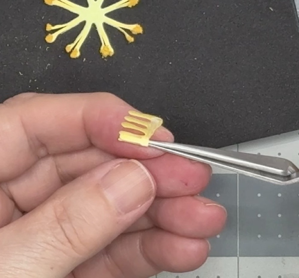 Screen shot showing how to roll the flower center after adding a bit of glue to the base.