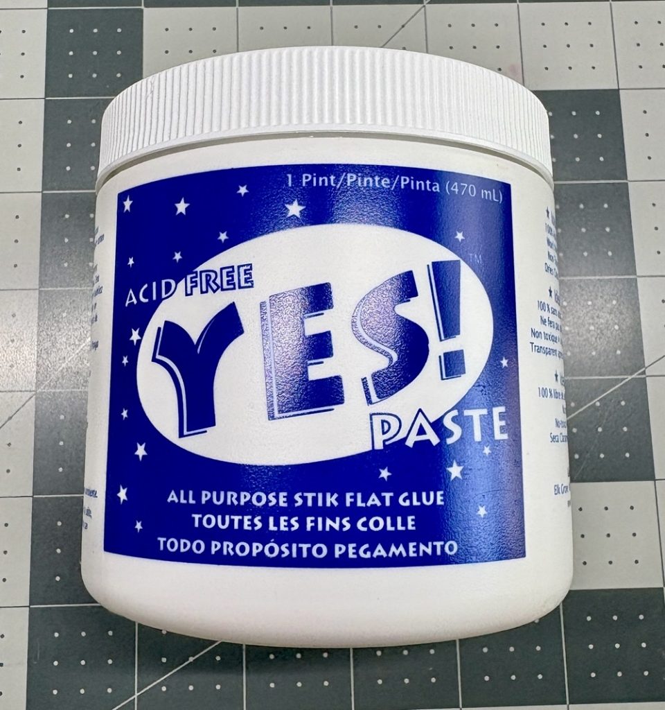 Photo of the container of Yes! Paste that will be used to adhere the flower to the plastic ornament for today’s Handmade Christmas Ornament with a Cardstock Flower project.