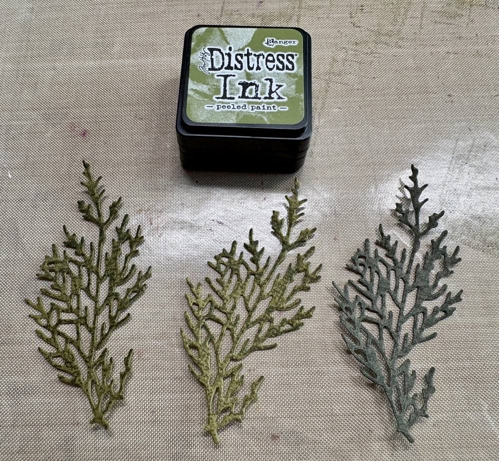 Photo of the green branches after having the color added from the peeled paint distress ink cube.