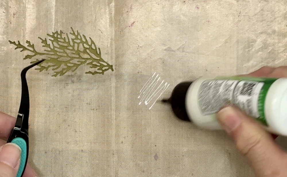 Screen show showing the application of a bit of Bearly Art Glue to a Teflon mat.