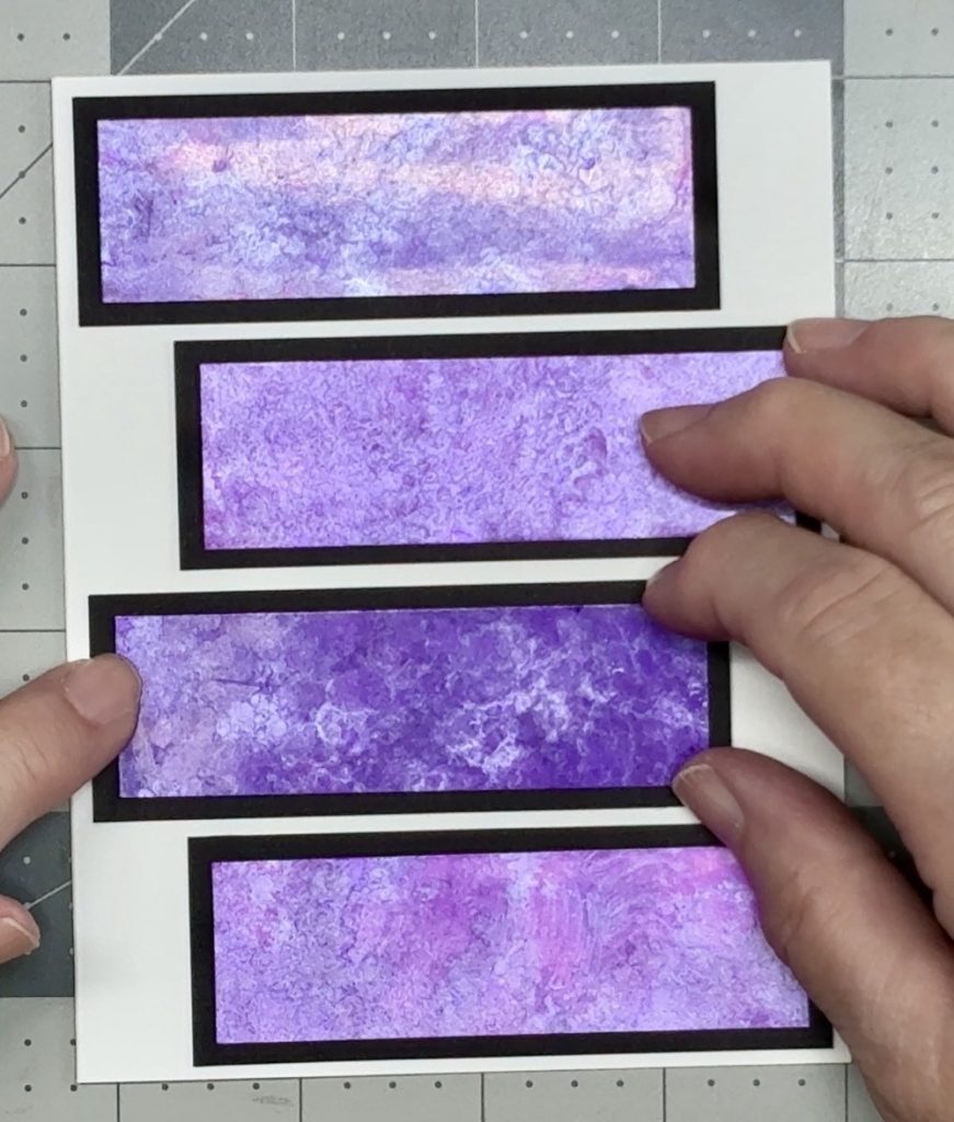 Screen shot showing the last alcohol inked strip being placed in the center of the card and staggered off to the left.