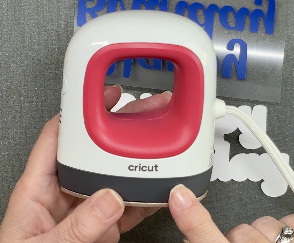 Screen shot showing the Cricut EasyPress Mini Heat Press used to apply the HTV to the text mat for today's Easy Birthday Cake Topper with Cricut project.