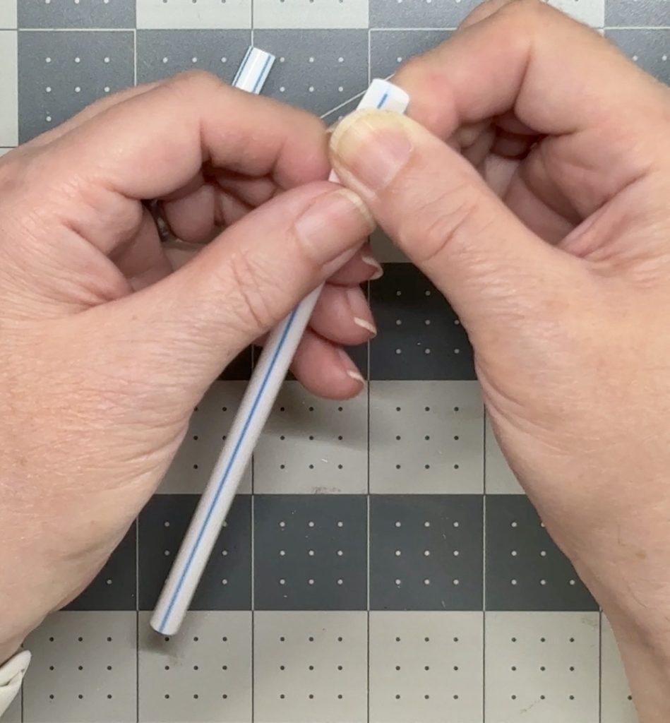 Screen shot showing how I flatten the end of each straw with my fingers to lessen the thickness between layers of the cake topper.