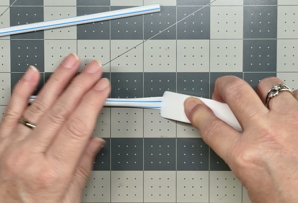 Screen shot showing how I switch from my fingers to my bone folder to flatten the end of the straws even more for today's Easy Birthday Cake Topper with Cricut post.