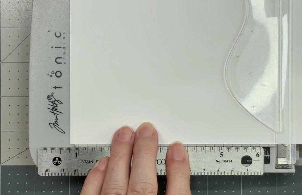 Photo showing how I extend the cutting measurements with a small ruler to cut the card base to a width of 6 ¼” from Recollections 110lb cardstock.