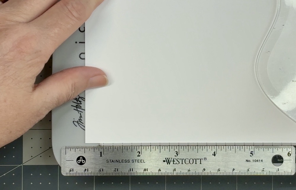 Photo showing how I extend the cutting measurements with a small ruler to cut the card base to 6 ½” tall.