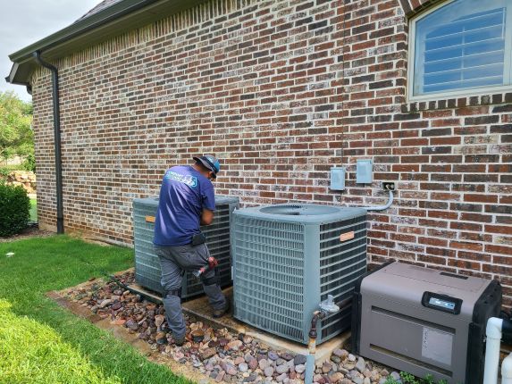 A Comfort Conditioning technician performs air conditioner maintenance in Krum, Texas