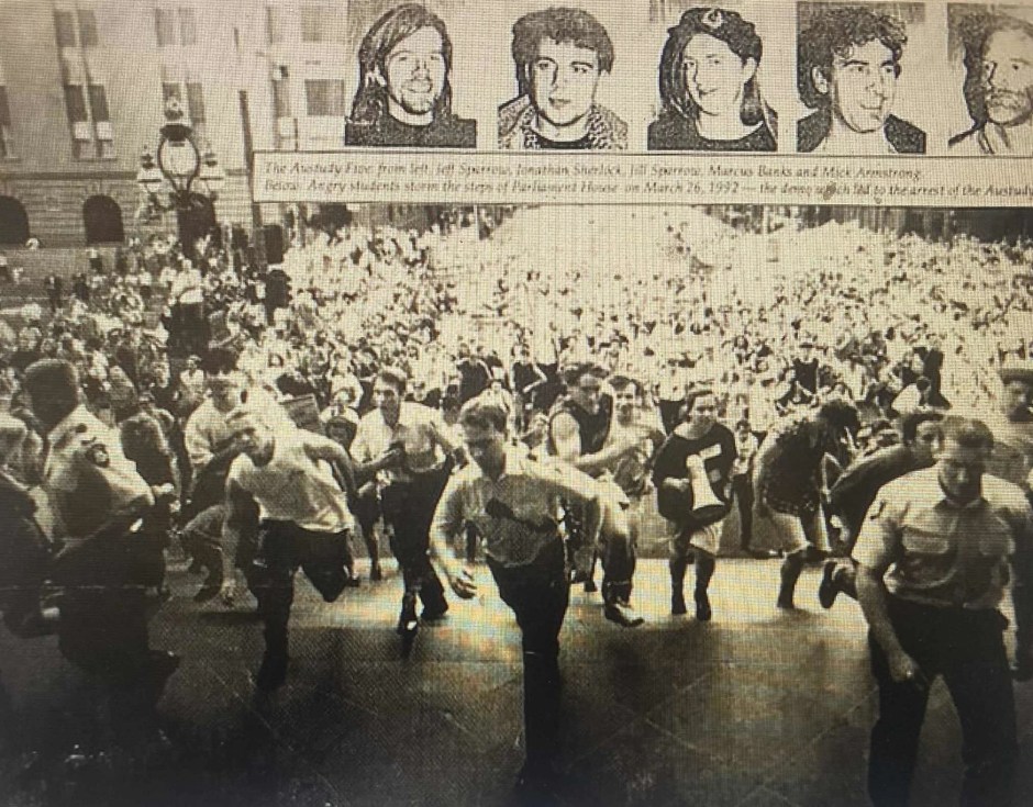 A photo of a large crowd of students running up the stairs of Victorian parliament with police in front of them.