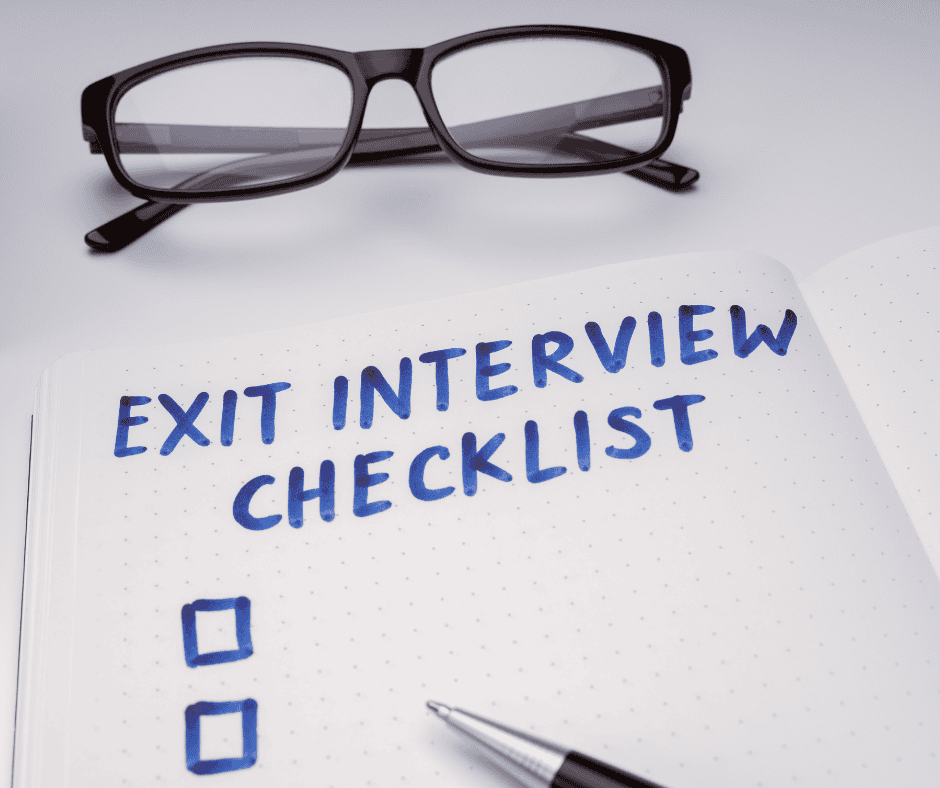 Photo of book with checkbox and pen. Text reads 'Exit Interview Checklist'. There are a pair of reading glasses sitting above book