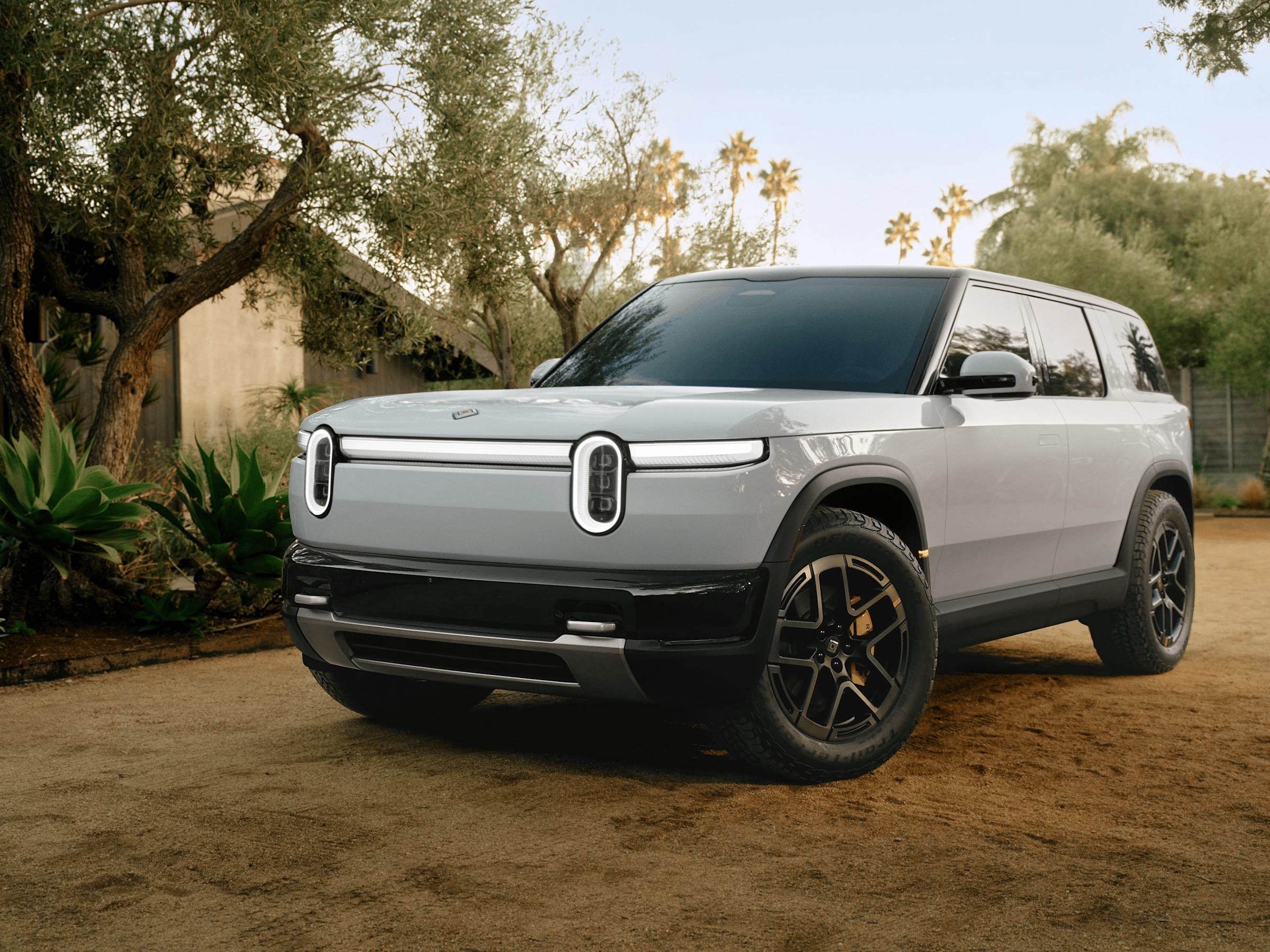 Rivian R2 electric SUV shown from the front against an outdoor landscape.