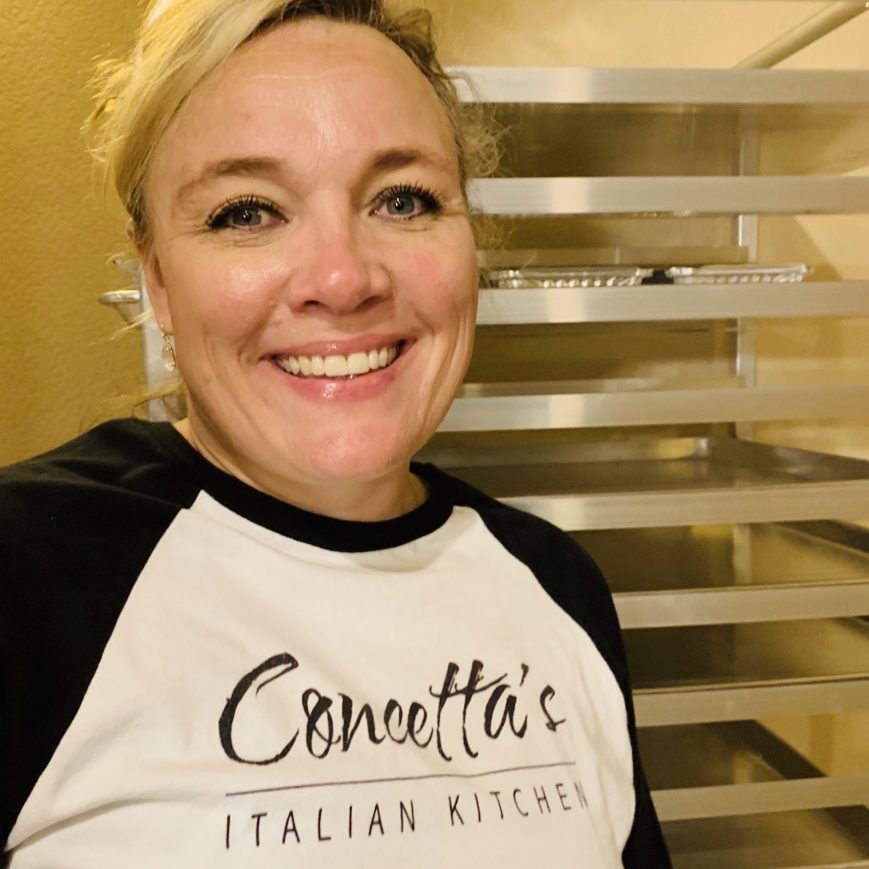 Smiling woman in Concetta's Italian Kitchen shirt