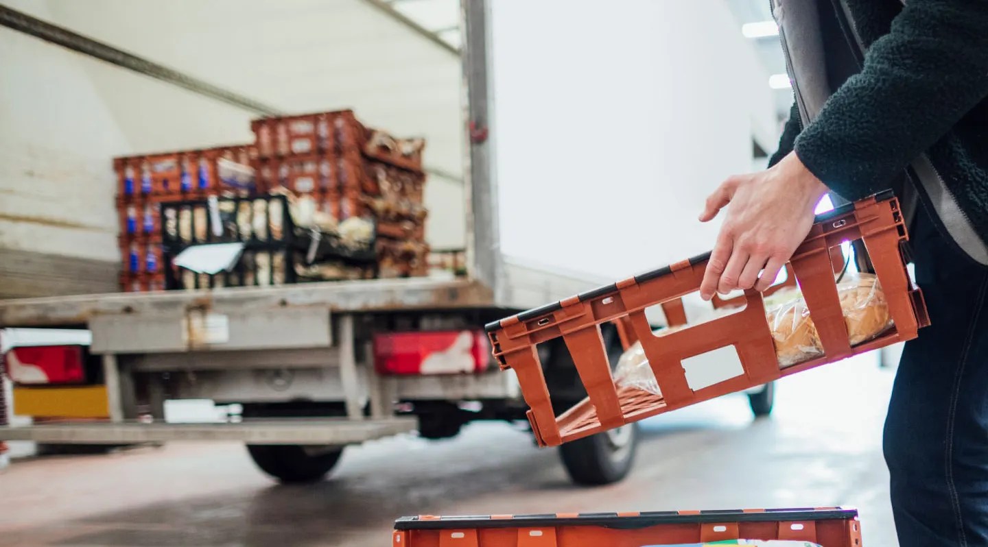 Driver handling food crates at a delivery