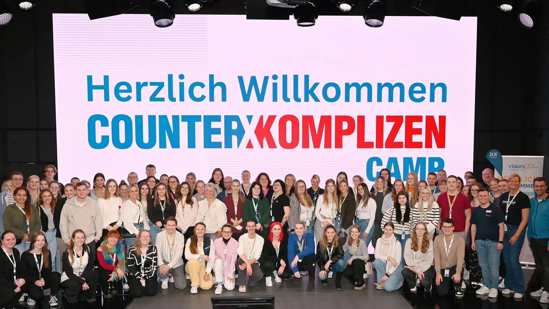 Große Gruppe junger Tourismusprofis vor der CounterKomplizen Camp Bühne