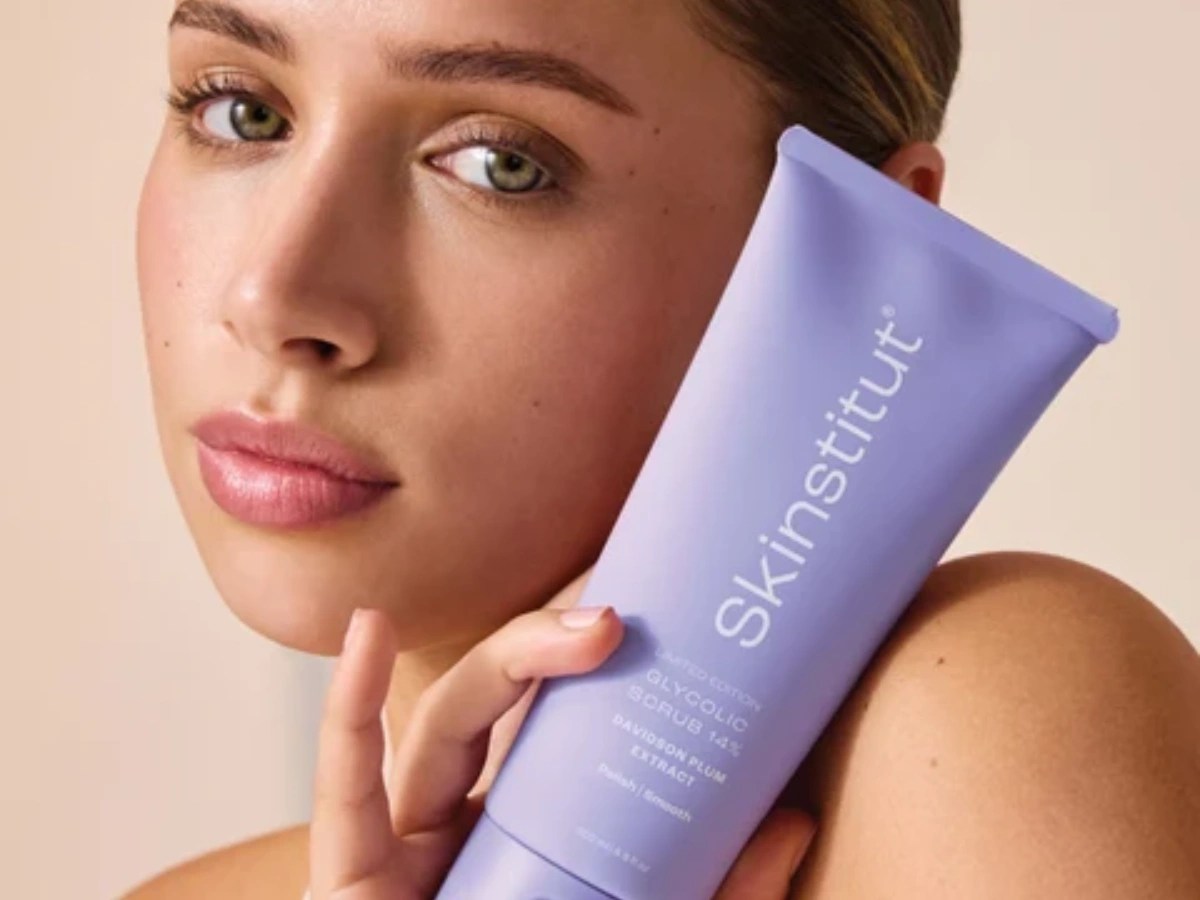 Skinstitut limited edition Glycolic Scrub held by a woman