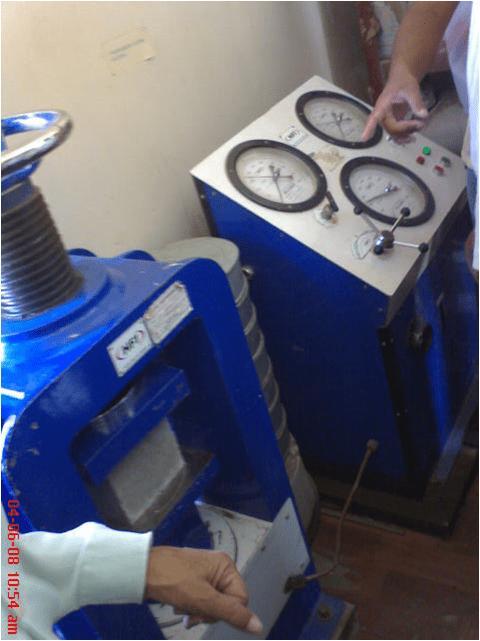 COMPRESSION TESTING MACHINE FOR THE CONCRETE CUBES. Left : Cube clamping mechanism Right : Dial indicators to note down the crushing load.