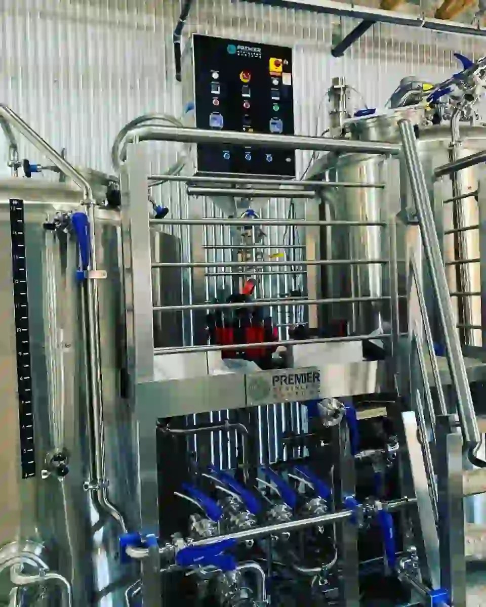 Control panel with switches and digital controllers above a stainless platform and butterfly valve manifold.