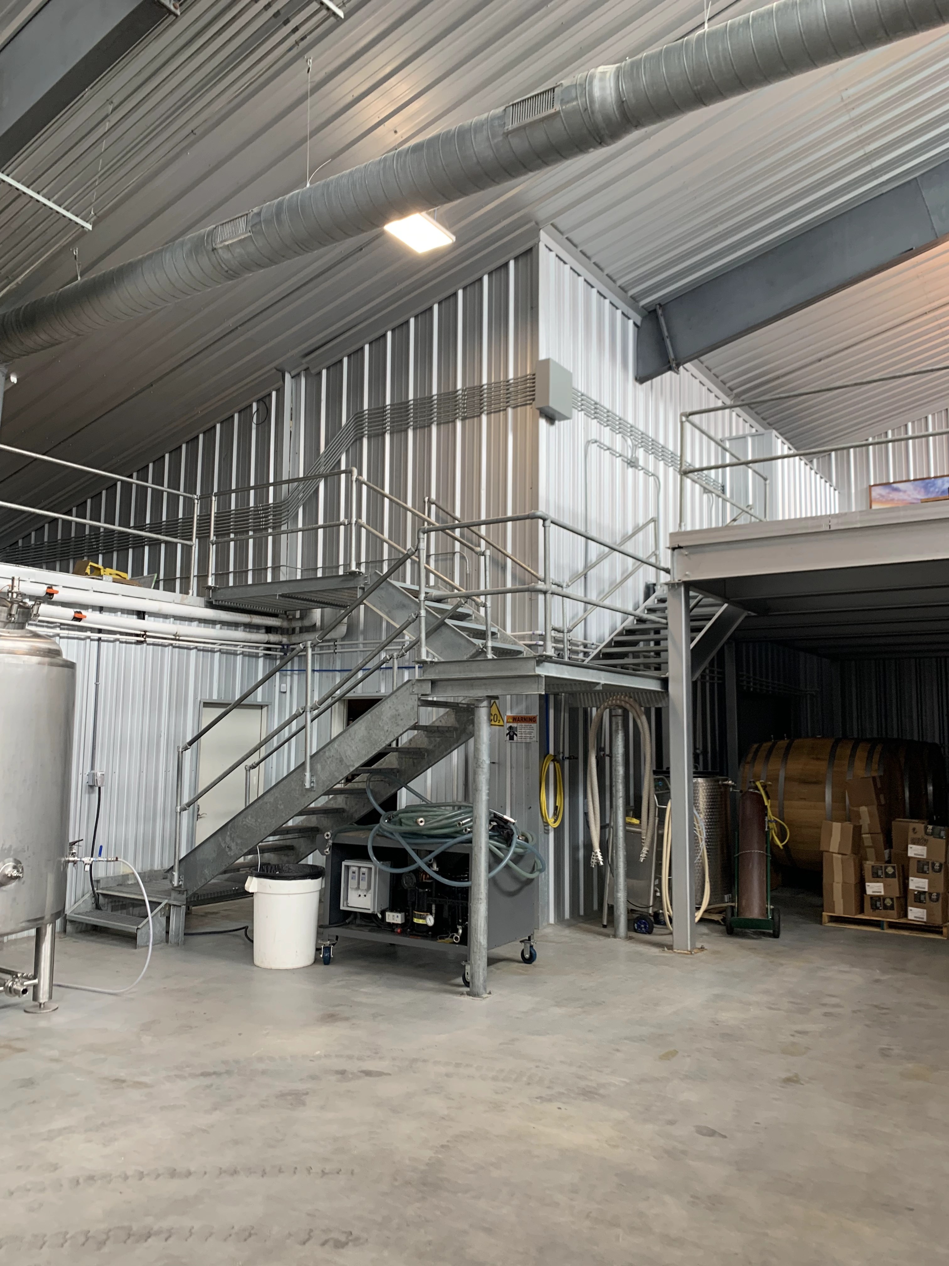 Augusta Vin winery floor with steel stairs to a mezzanine catwalk and a stainless tank