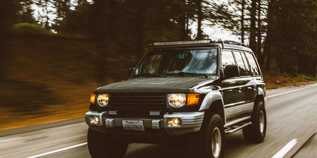timelapse photography of green SUV on road