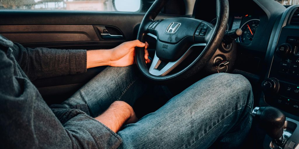 person holding black Honda car steering wheel