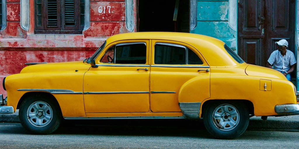 yellow sedan parked near red concrete building