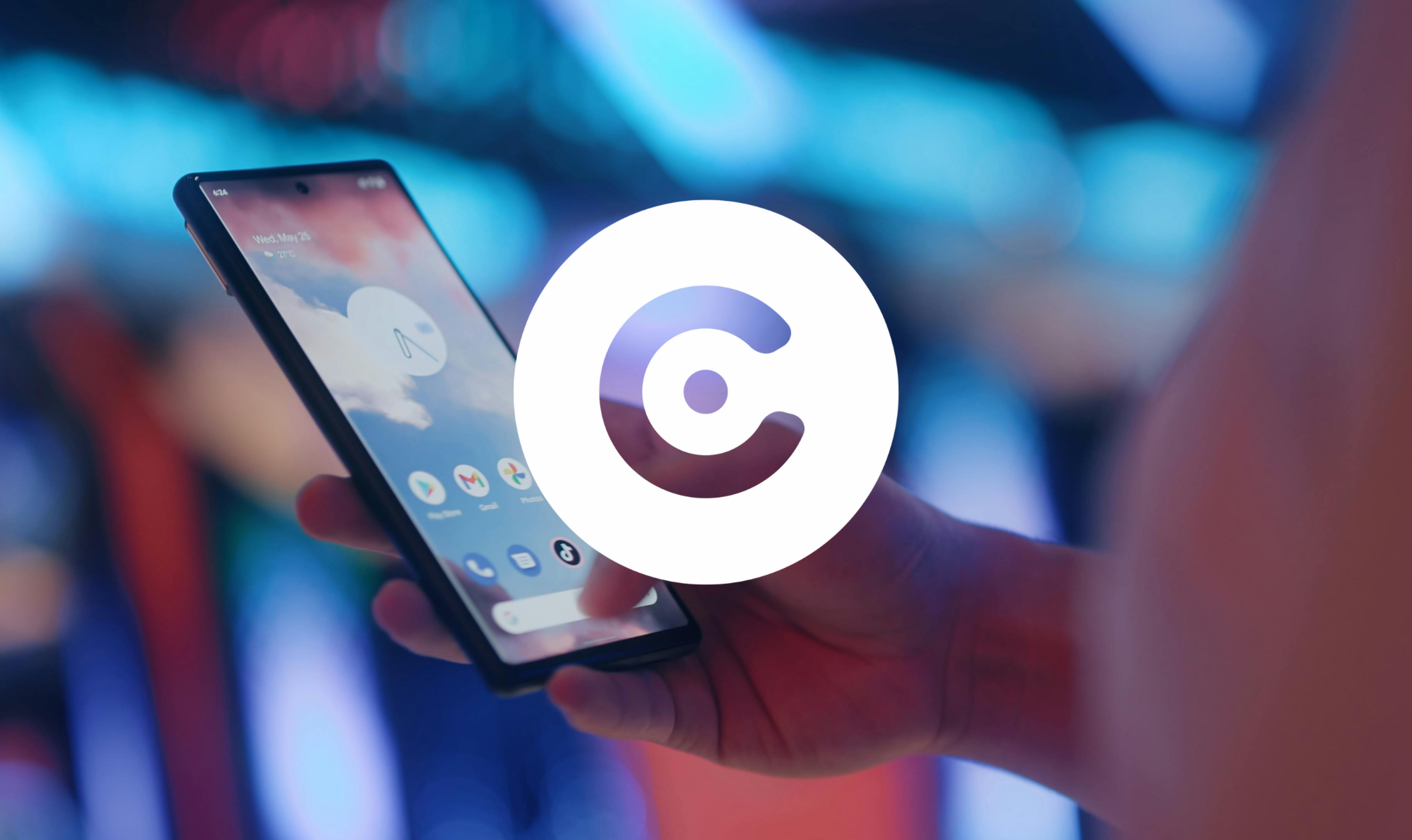 The image shows a person holding a smartphone with the home screen visible, displaying app icons like Gmail, Google, and TikTok. The phone background features a cloudy sky. The background is blurred with blue and pink lighting, creating a modern tech atmosphere. A large white circular logo with a dot and cutout shape is overlaid prominently in the center of the image.