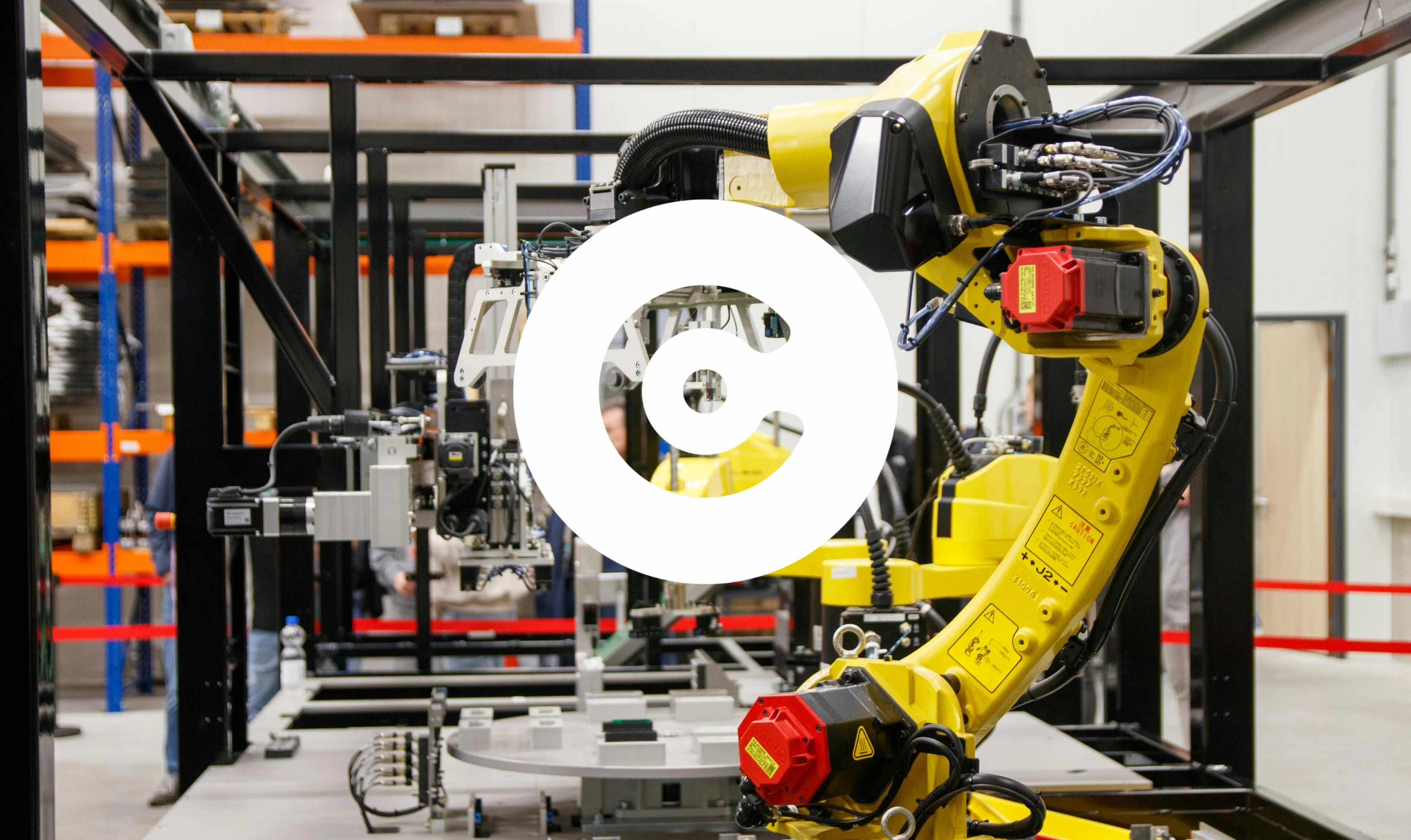 Yellow industrial robotic arm operating inside a factory automation cell.