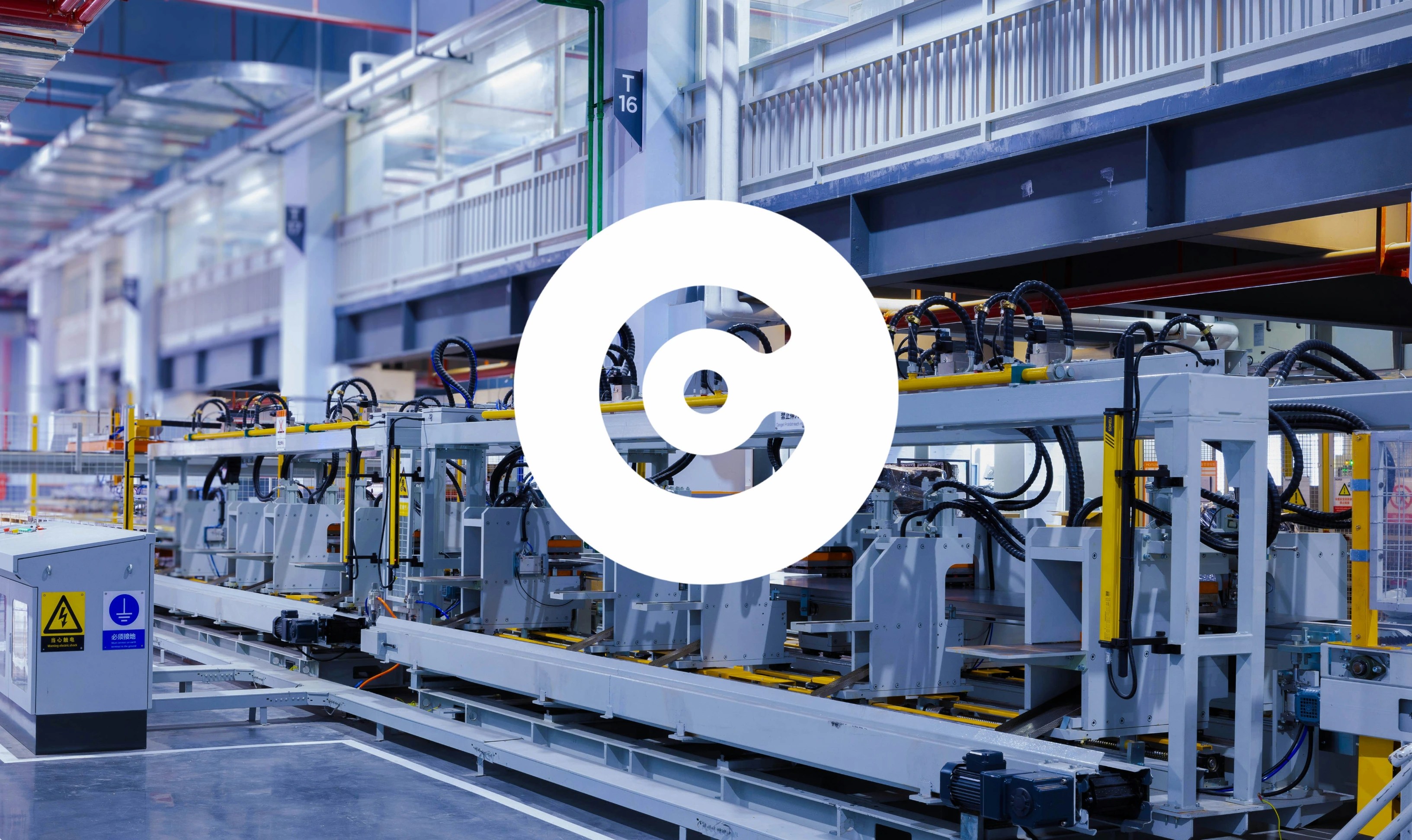 Automated industrial production line inside a modern factory hall, with conveyor systems and machinery, overlaid by a large white circular logo in the center.
