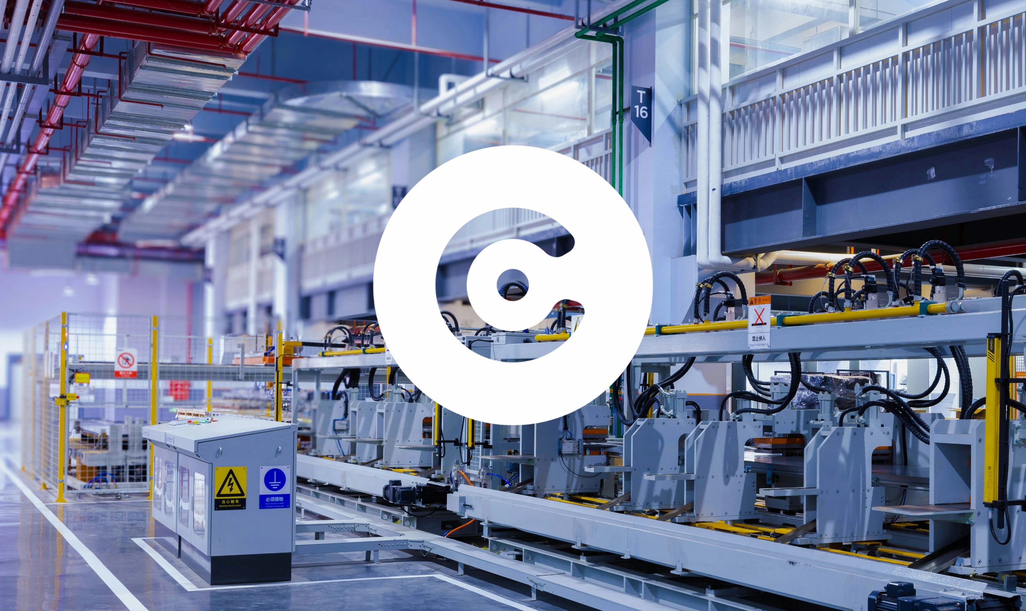 Modern industrial production line inside a large factory hall, with automated machinery, conveyor systems, and overhead piping in a clean high-tech manufacturing environment.
